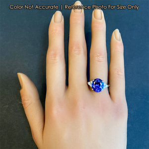 oval tanzanite and diamond ring on hand for size reference