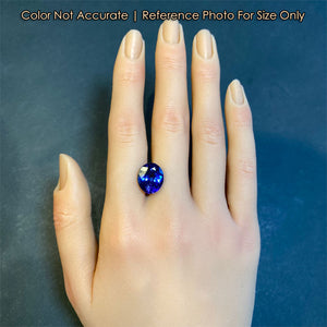 Oval cut tanzanite gemstone on hand mostly blue color