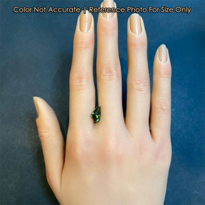 green freeform step cut tanzanite on hand