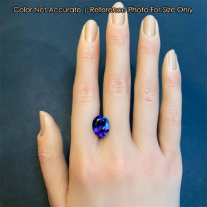 mostly blue oval cut tanzanite gemstone on hand size