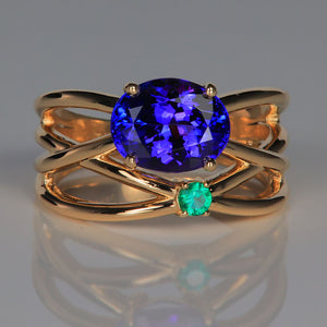 oval cut tanzanite with emerald accent ring in yellow gold
