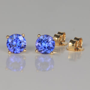 mostly blue color tanzanite gemstone earrings in yellow gold round brilliant cut