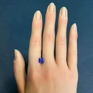 violet blue tanzanite gemstone on hand
