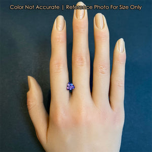 blue violet tanzanite gem on hand for size