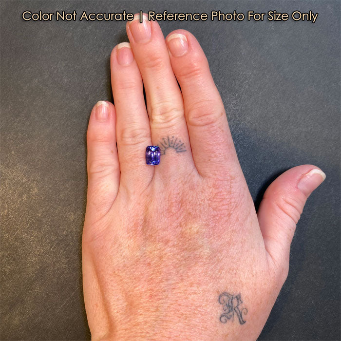 blue violet tanzanite gemstone on a hand