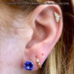 white gold tanzanite studs on ear