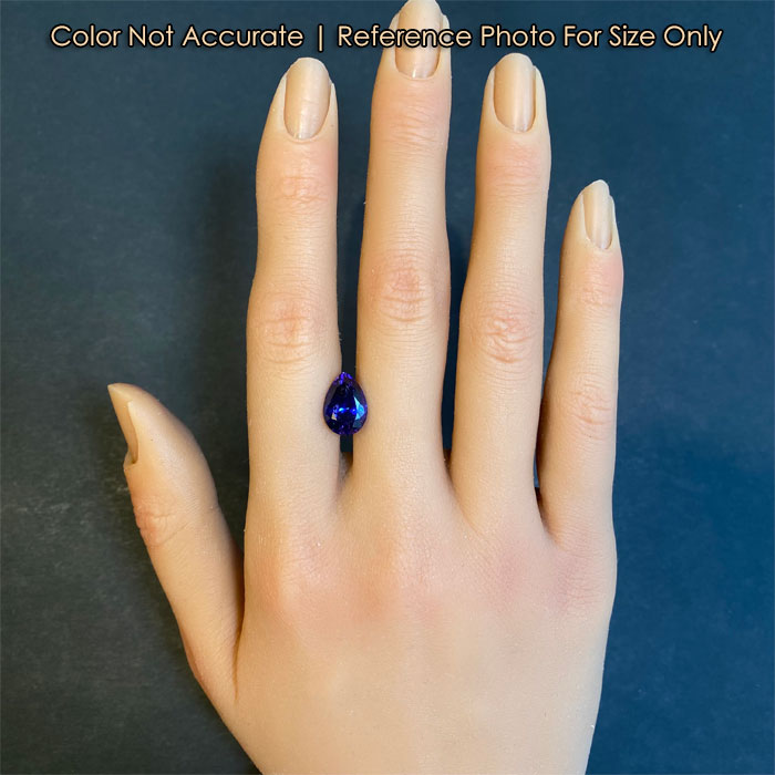 mostly blue tanzanite gemstone on a hand for reference