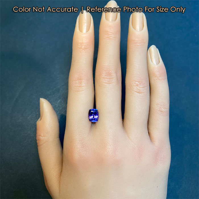 antique cushion tanzanite on hand for size reference