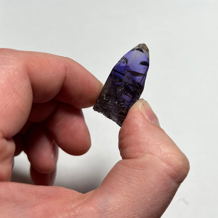 raw tanzanite crystal in hand