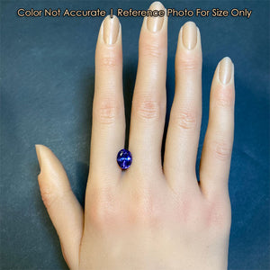 violet blue tanzanite gem oval cut on hand
