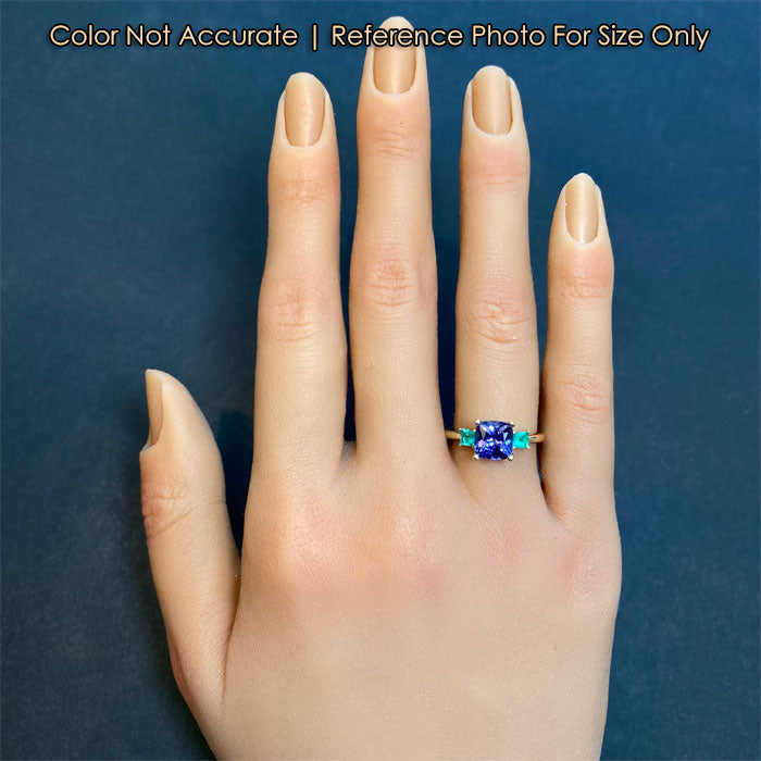 Yellow gold tanzanite ring with emerald accents on hand size