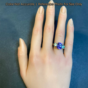 blue violet tanzanite gem with garnets in platinum ring
