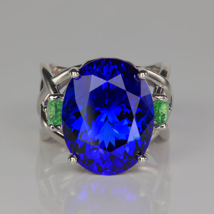 sapphire blue oval tanzanite gemstone ring in platinum with tsavorite garnets