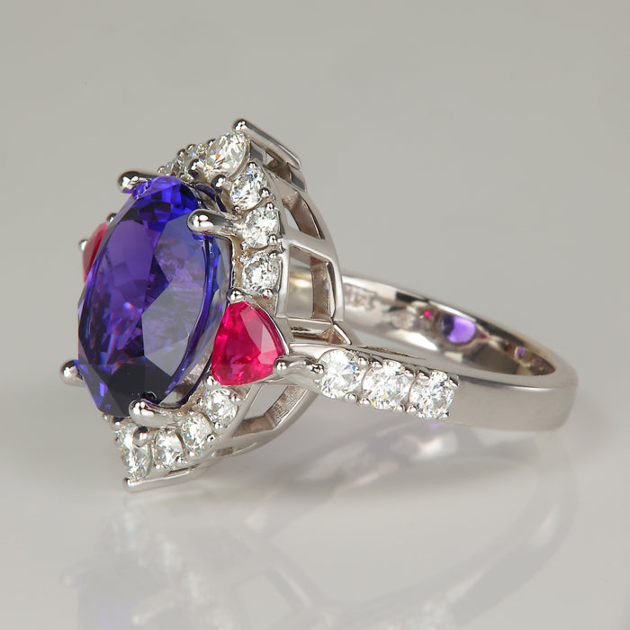 Oval cut tanzanite gemstone ring with trilliant cut ruby accents and diamonds in white gold 
