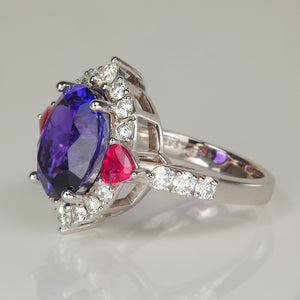 Oval cut tanzanite gemstone ring with trilliant cut ruby accents and diamonds in white gold 