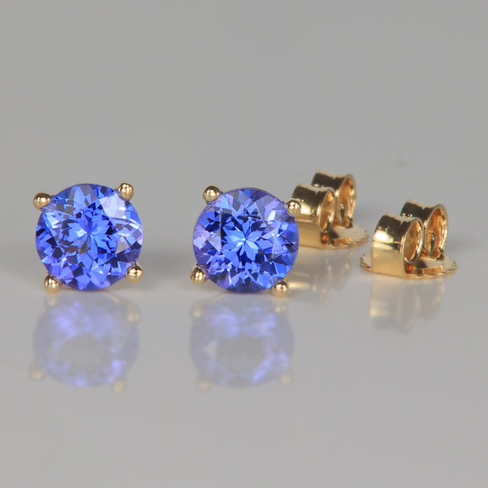 mostly blue color tanzanite gemstone earrings in yellow gold round brilliant cut