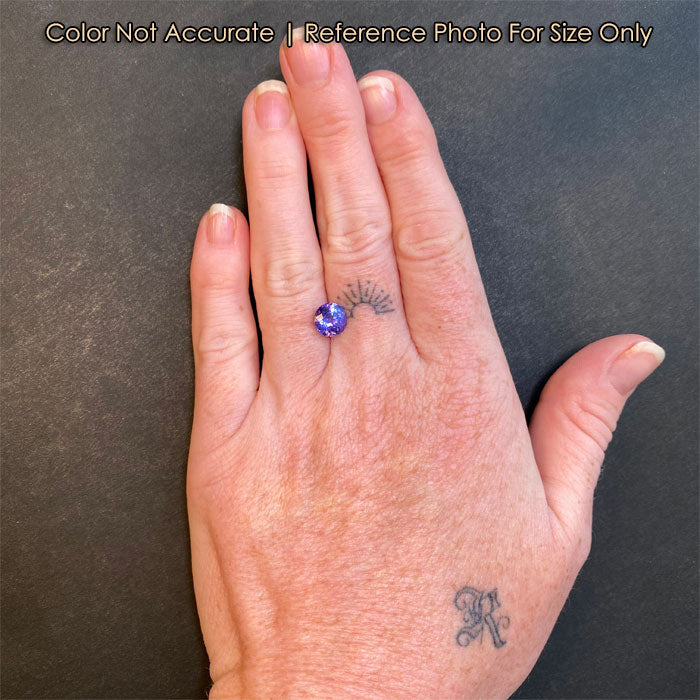round brilliant cut tanzanite on hand