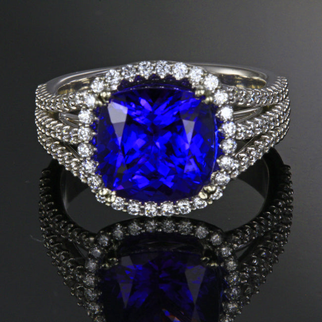 Ladies' 18k white gold tanzanite ring designed by Steve Moriarty, with one blue violet exceptional color, VS+ clarity square cushion tanzanite. The tanzanite weighs 4.25 carats, has been color enhanced by heating, measures 9.7 mm wide by 9.7 mm long by 6.